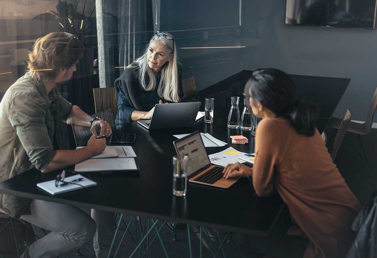 Volts Consulting team in a strategy meeting around a table with laptops